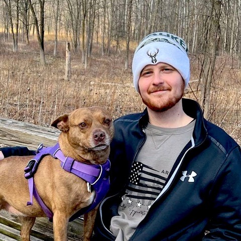 Tom on a bench in the woods with his dog